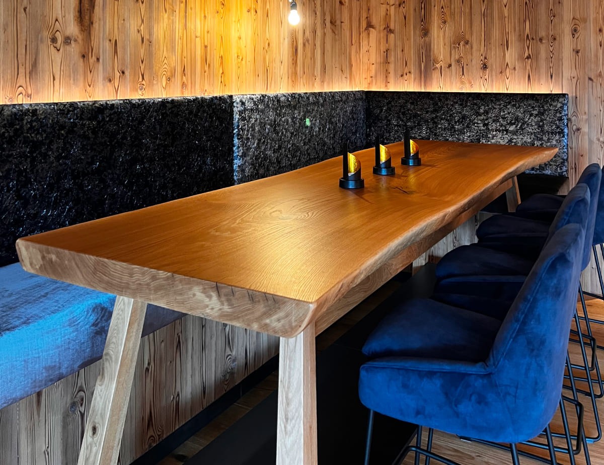 Holztisch im modernen Restaurant mit blauen St&uuml;hlen und stilvollen Kerzenhaltern