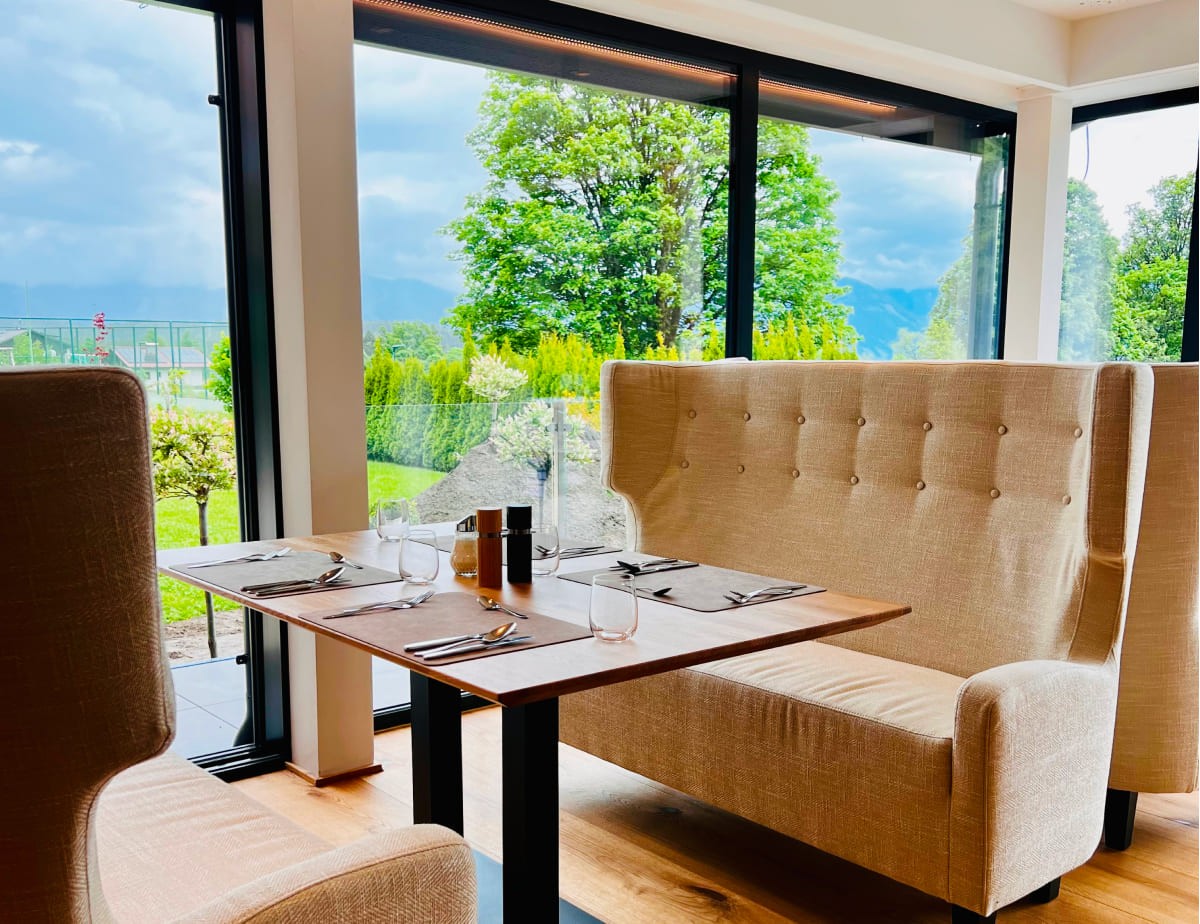Restauranttisch im Landhaus Ramsau mit Blick auf Garten durch gro&szlig;e Fenster
