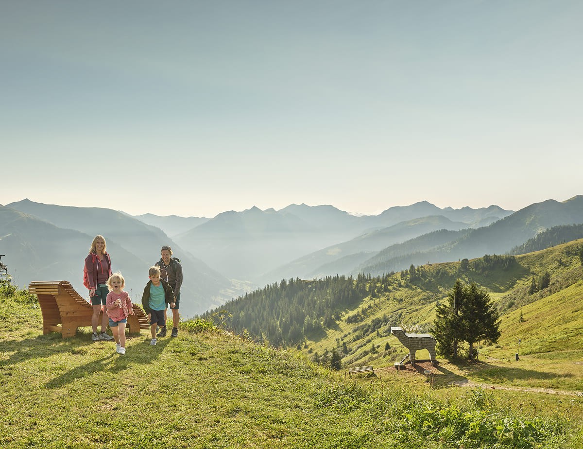 Wanderer auf einer sonnigen Alm vor der Bergkulisse &copy; Peter Burgstaller