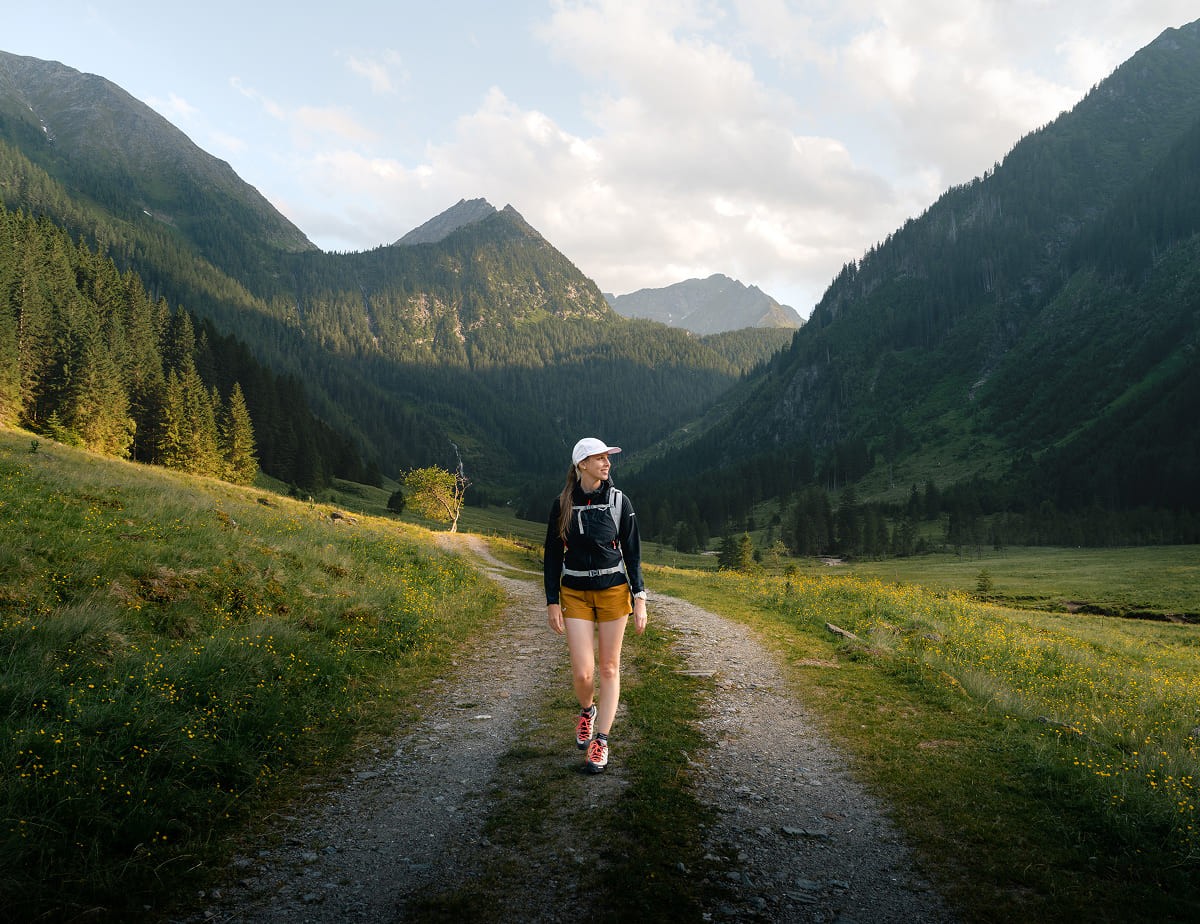 Wanderin auf einem Weg durch ein idyllisches Bergtal &copy; Christoph Lukas 