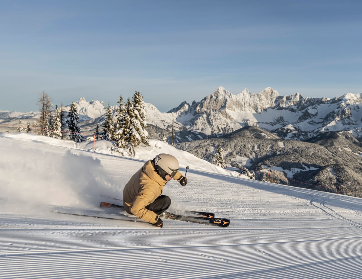 Skifahrer auf einer Piste mit Bergpanorama in Schladming-Dachstein (c) Mirja Geh