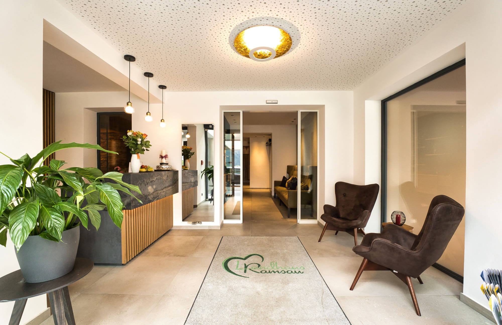 Moderner Hoteleingang mit Beleuchtung und beschrifteter Fußmatte im Landhaus Ramsau