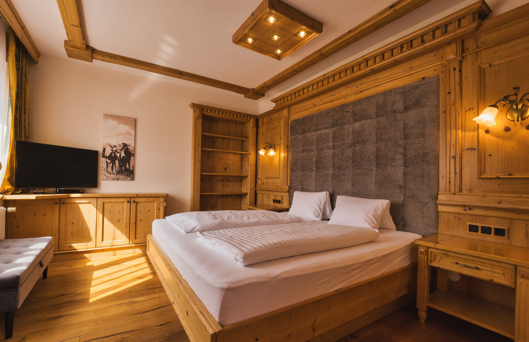 Ein gemütliches Schlafzimmer aus Holz mit einem großen Bett und Wandlampen
