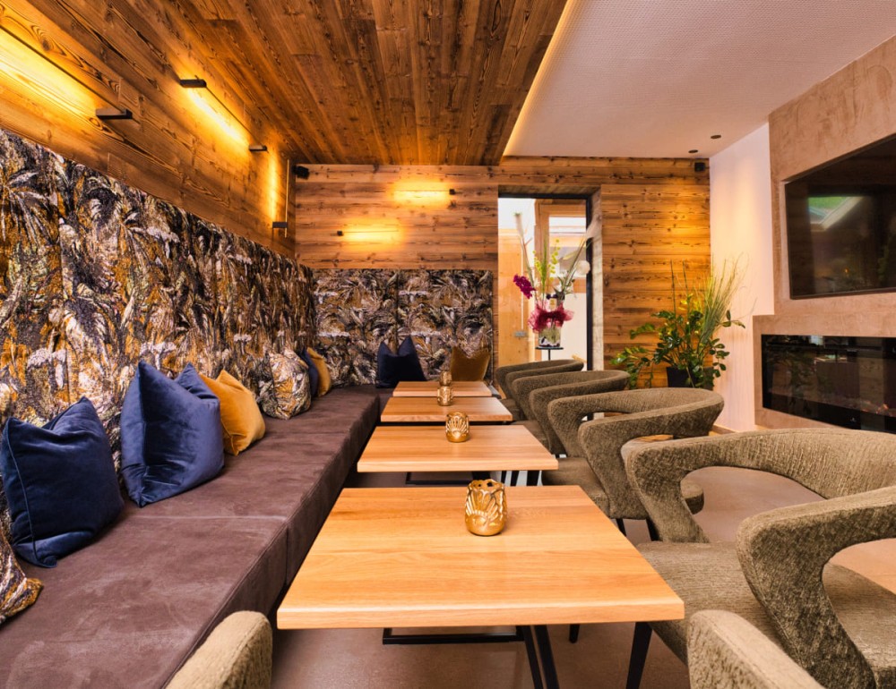 Gem&uuml;tliches Caf&eacute; mit Holzw&auml;nden, Pflanzen und modernem Sitzbereich