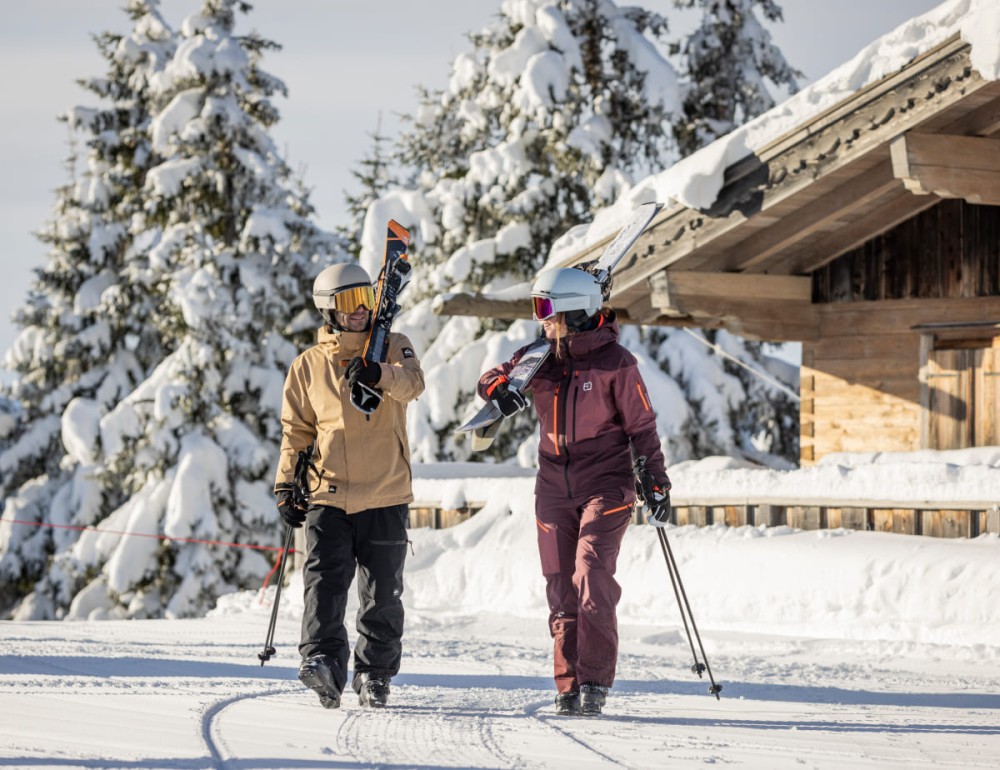 Skifahrer mit Skiern auf dem Weg zur Piste in Ramsau am Dachstein (c) Mirja Geh (12-2023)