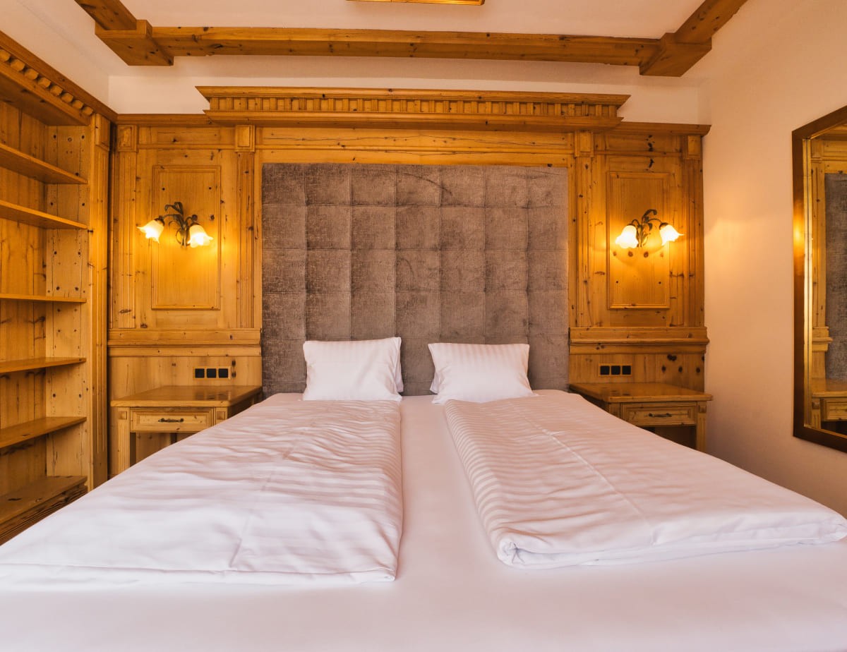 Doppelzimmer Deluxe mit Dachsteinblick mit Holzverkleidung und einem gro&szlig;en Doppelbett