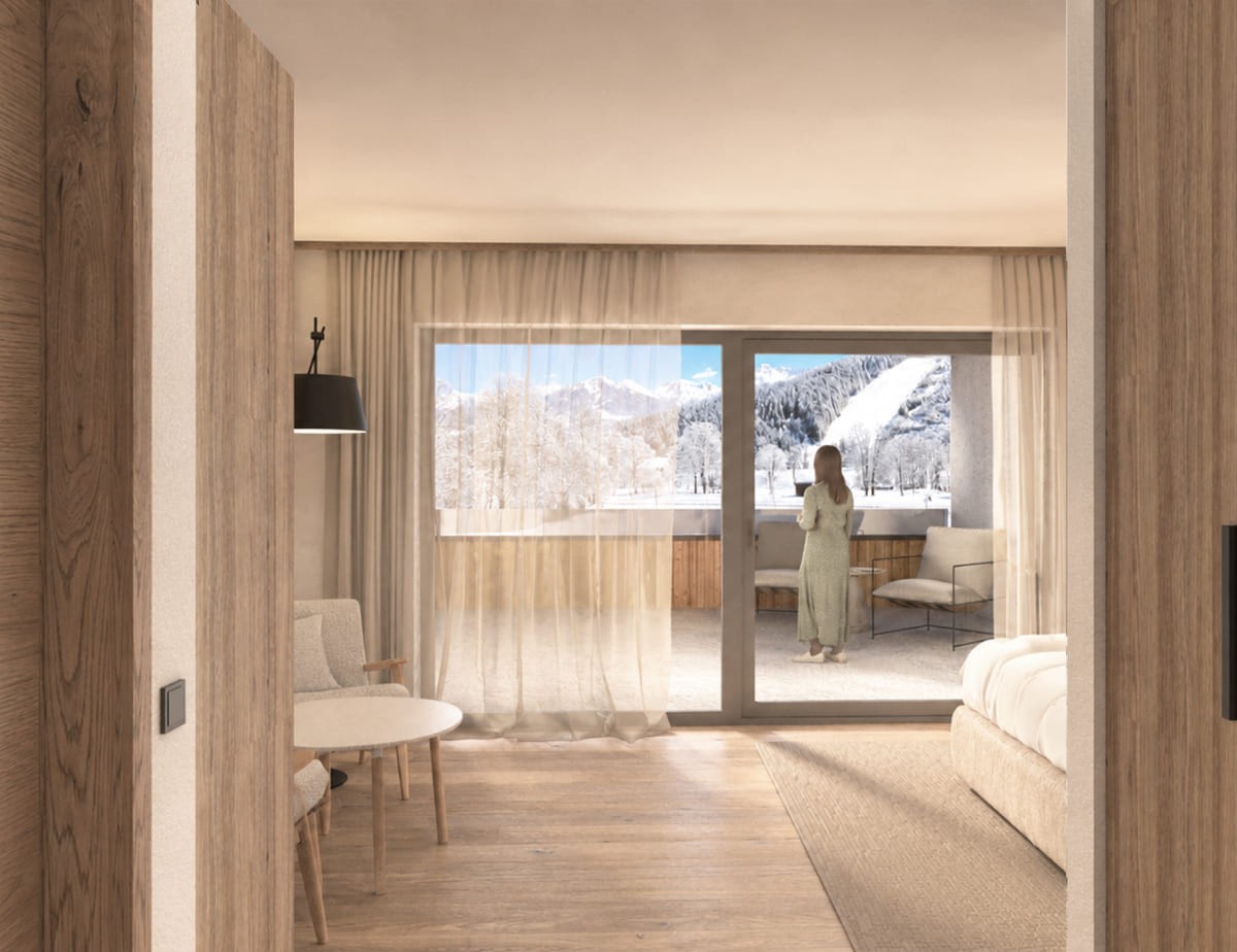 Visualisierung vom neuen Zimmer im Hotel Landhaus, eine Frau steht in einem Zimmer mit Blick auf schneebedeckte Berge