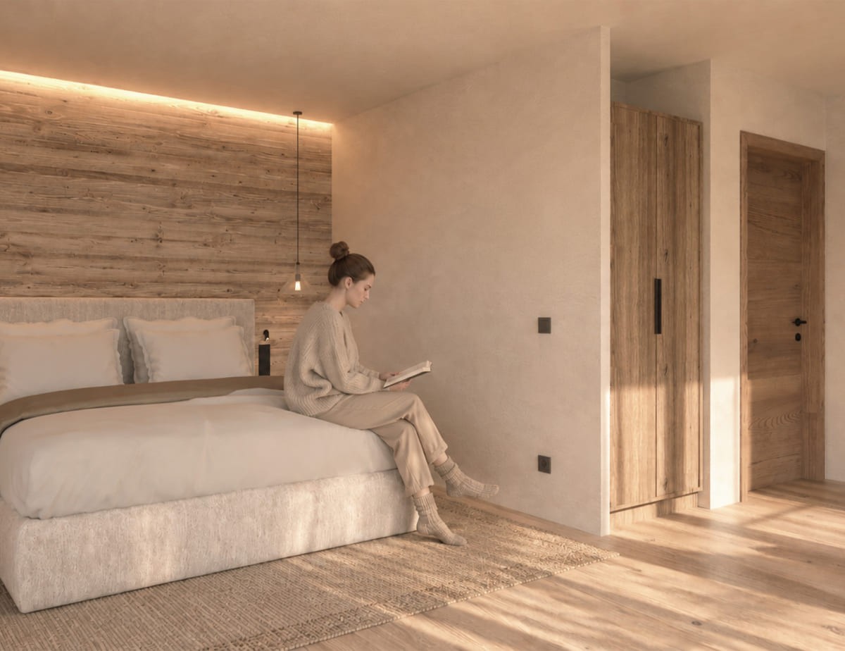 Visualisierung vom neuen Zimmer im Hotel Landhaus, eine Frau liest auf einem Bett in einem modernen, minimalistisch eingerichteten Zimmer